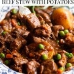 A close up of a fork picking up some beef stew from a bowl. The text overlay reads: Cozy Italian Beef Stew with Potatoes