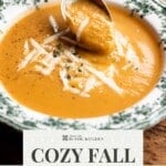 A Pinterest graphic showing a plate of roasted vegetable soup and a spoon picking up some from the bowl. the text overlay reads: Cozy Fall Vegetable Soup - Get the Recipe.