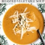 An overhead shot a bowl of roasted vegetable soup topped with cheese. The text overlay reads: Cozy fall Roasted Vegetable Soup.