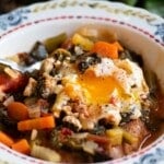 A close up of acquacotta in a bowl topped with a runny poached egg.