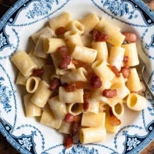 A cropped close up of Pasta alla Gricia in a blue and white bowl.