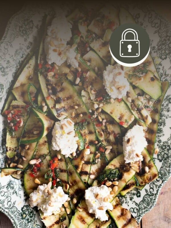 Grilled zucchini with ricotta and chilli on a plate with a padlock sign in the right hand corner to signify member only content.