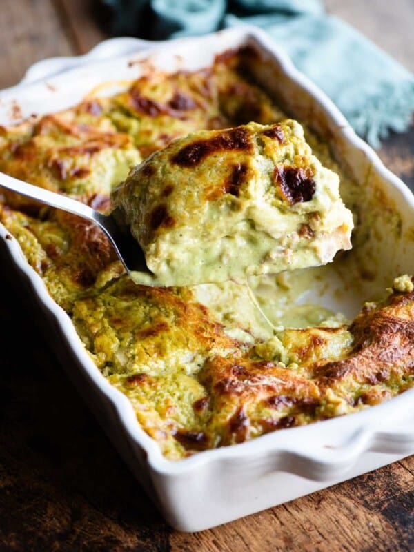 A spatula picking a slice of pistachio lasagna from a baking dish.