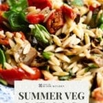 A close up of a pinterest pin showing an orzo pasta salad. The text overlay reads; Summer Veg Pasta Salad - Get the recipe.
