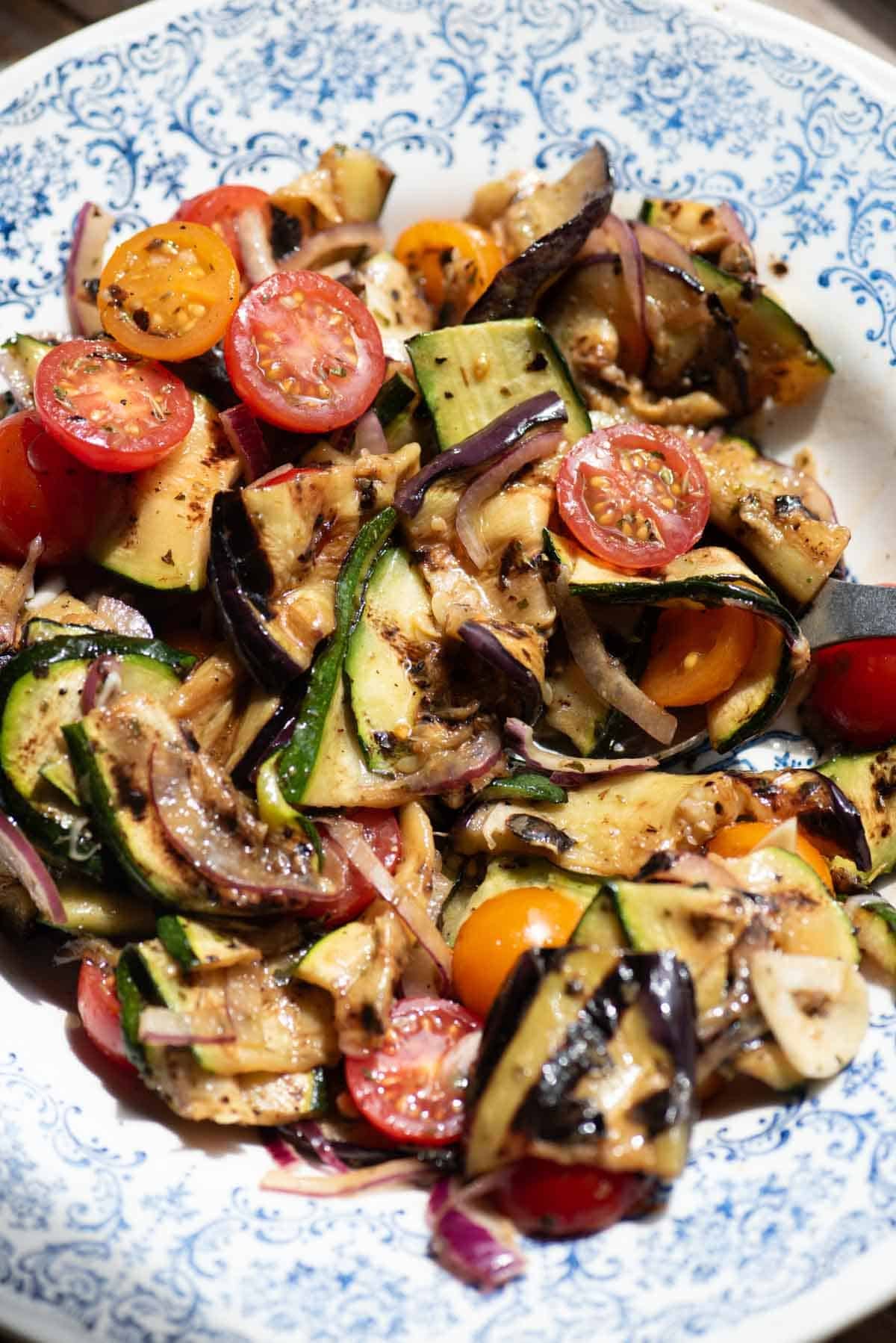 A close up of marinated grilled vegetables in a bowl.