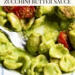 A close up pinterest graphic of orecchiette pasta in a vibrant green zucchini sauce. The text overlay reads, summer pasta with zucchini butter sauce.