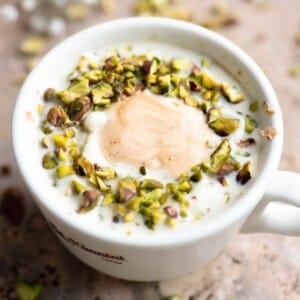 A close up cropped image of a pistachio affogato in a white mug.
