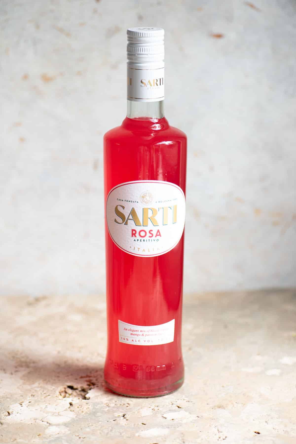 A bottle of Sarti liqueur on a neutral background.