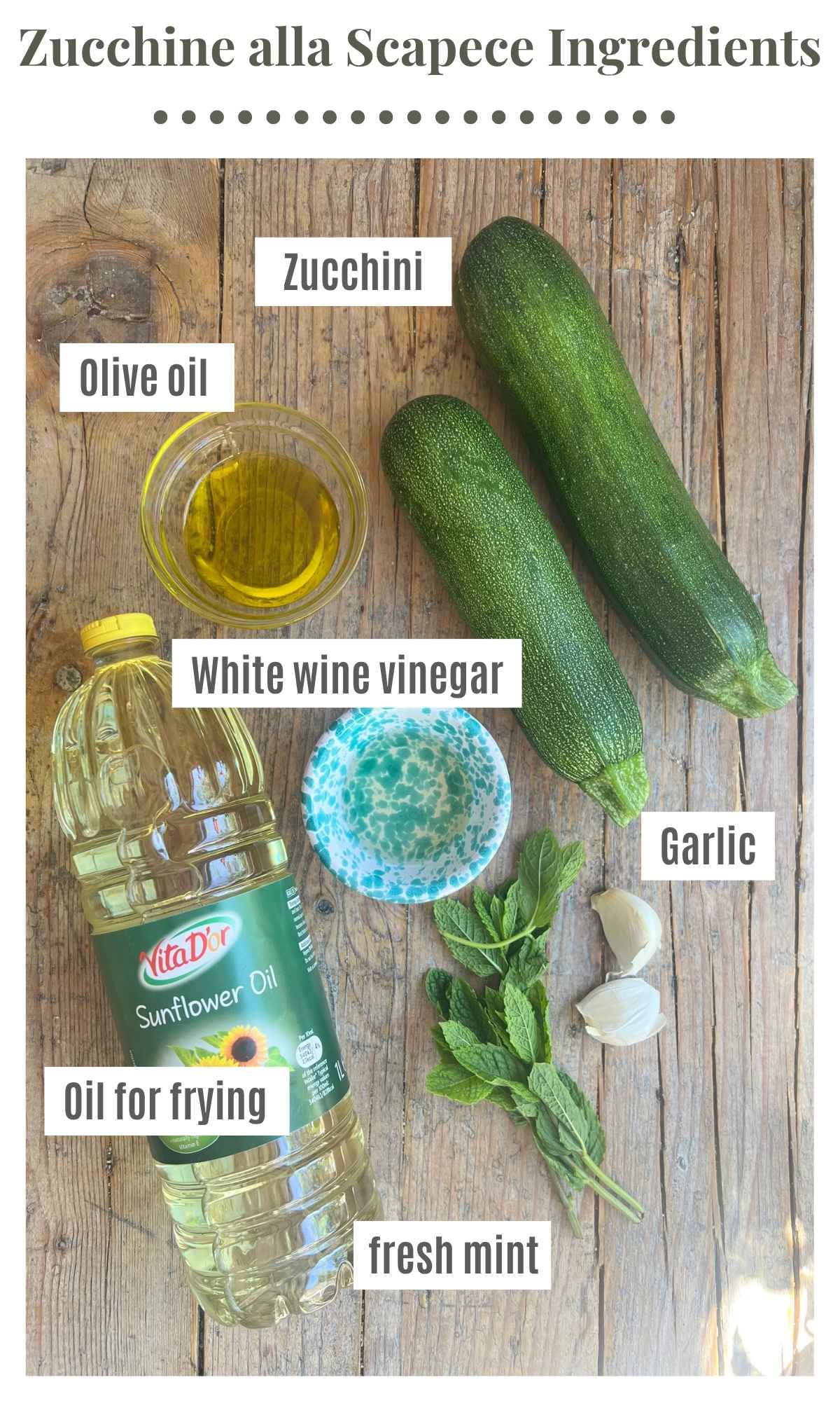 An overhead shot of all the ingredients needed to make zucchine alla scapece on a wooden board.