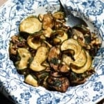A cropped close up image of fried zucchini in a blue and white bowl.