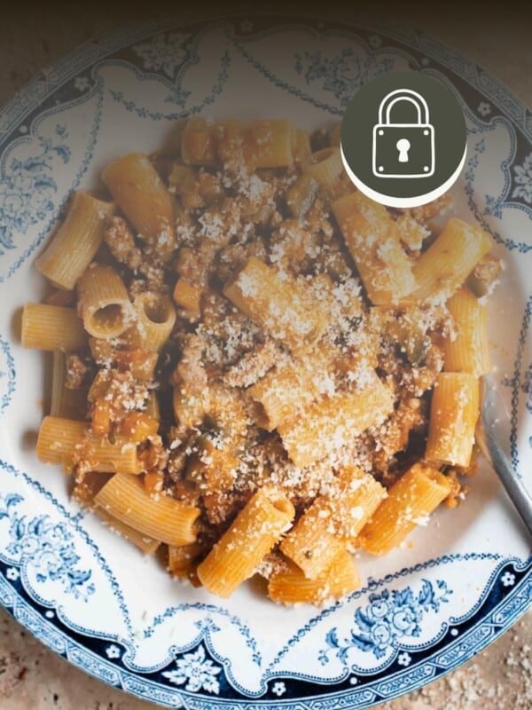 A sausage ragu in a blue and white bowl on a travertine surface. There is a padlock symbol in the top right corner to signify a member only recipe.