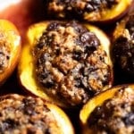 A close up of a baked peach stuffed with amaretti cookies and chocolate.