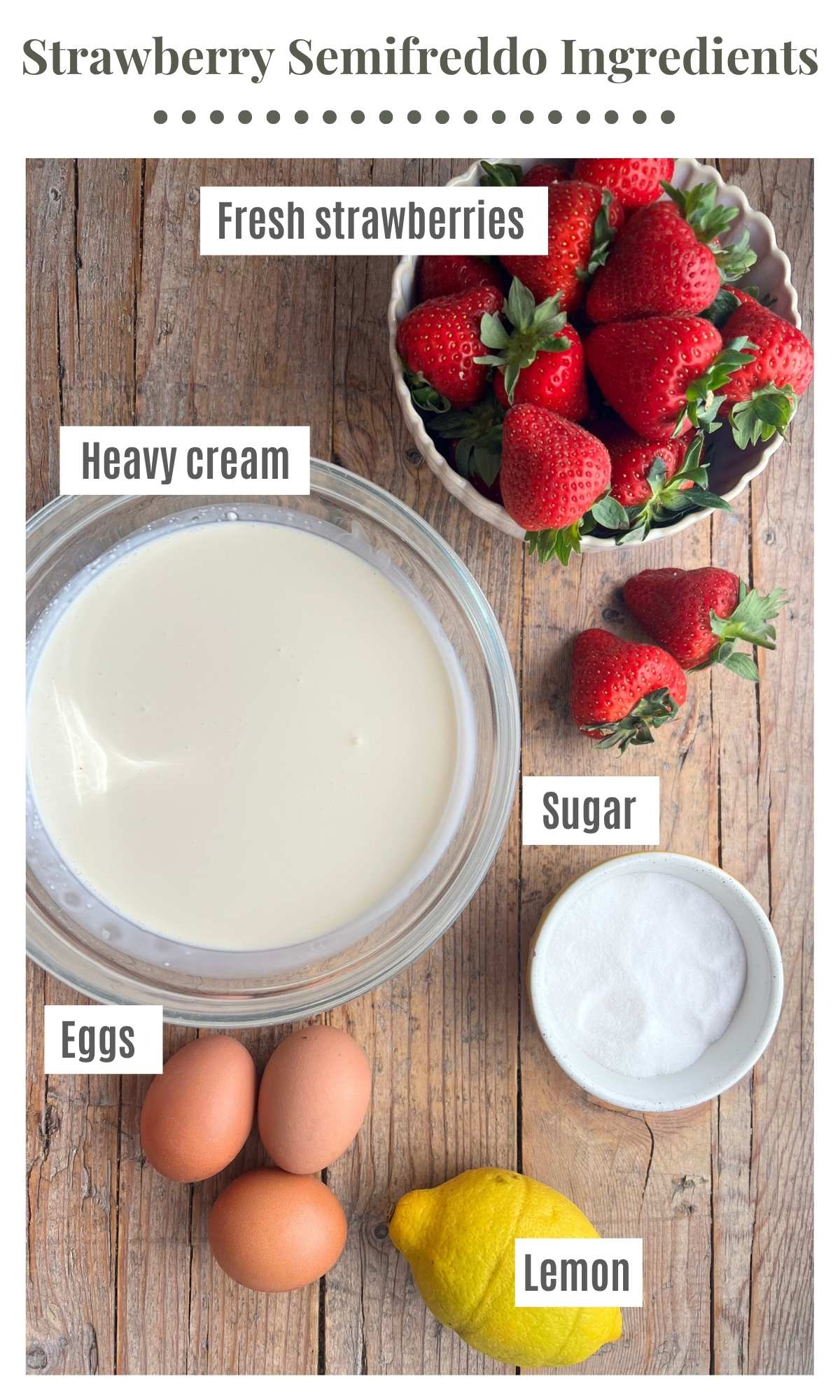 An overhead shot of all the ingredients needed to make strawberry semifreddo laying on a rustic wooden surface. Strawberries, cream, sugar, eggs and lemon.