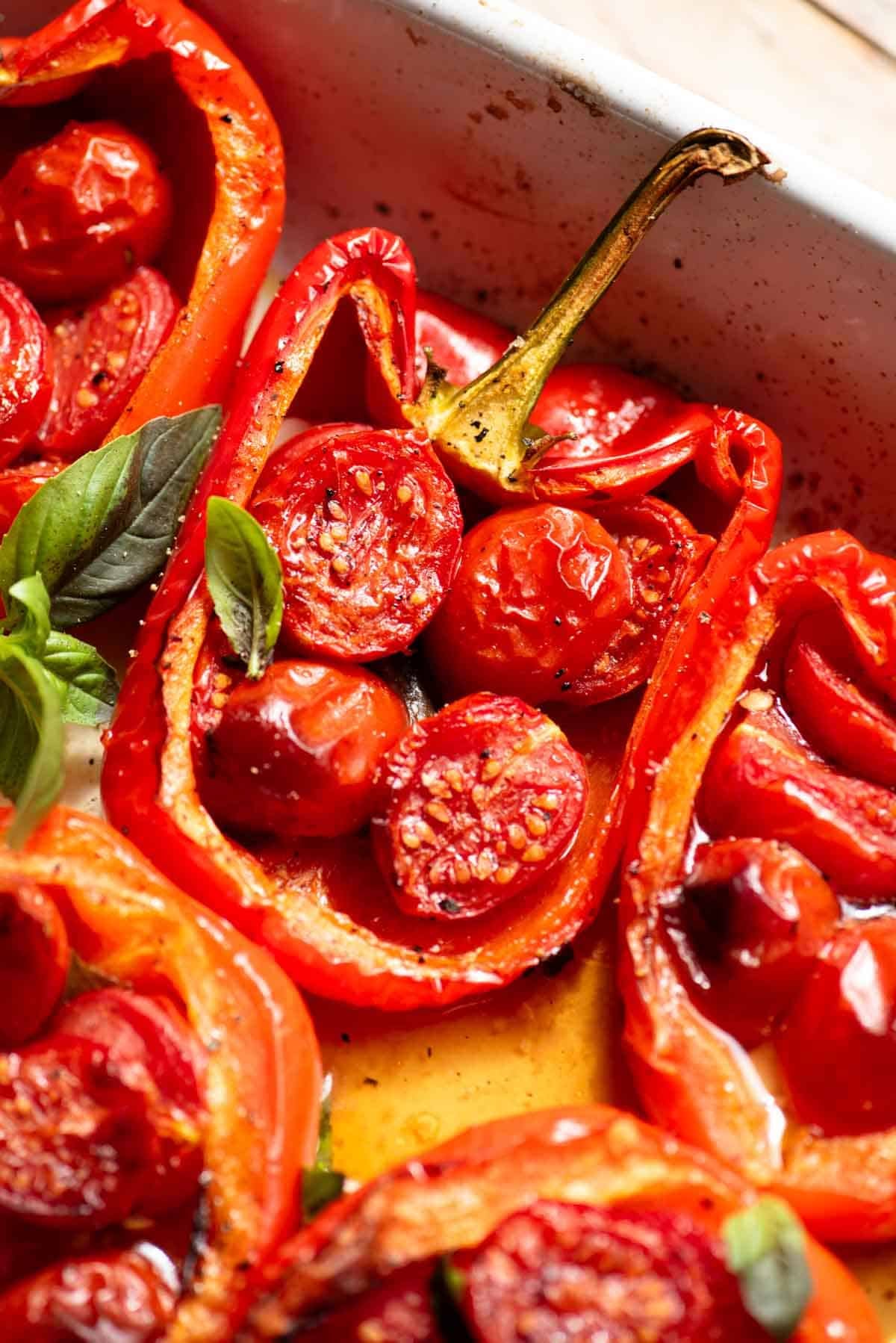 These delicious Italian stuffed peppers are stuffed with anchovies, garlic, basil and cherry tomatoes. A super easy and speedy lunch or dinner that you'll love! www.insidetherustickitchen.com A close up of a red bell pepper stuffed with cherry tomatoes, basil, garlic and anchovies.