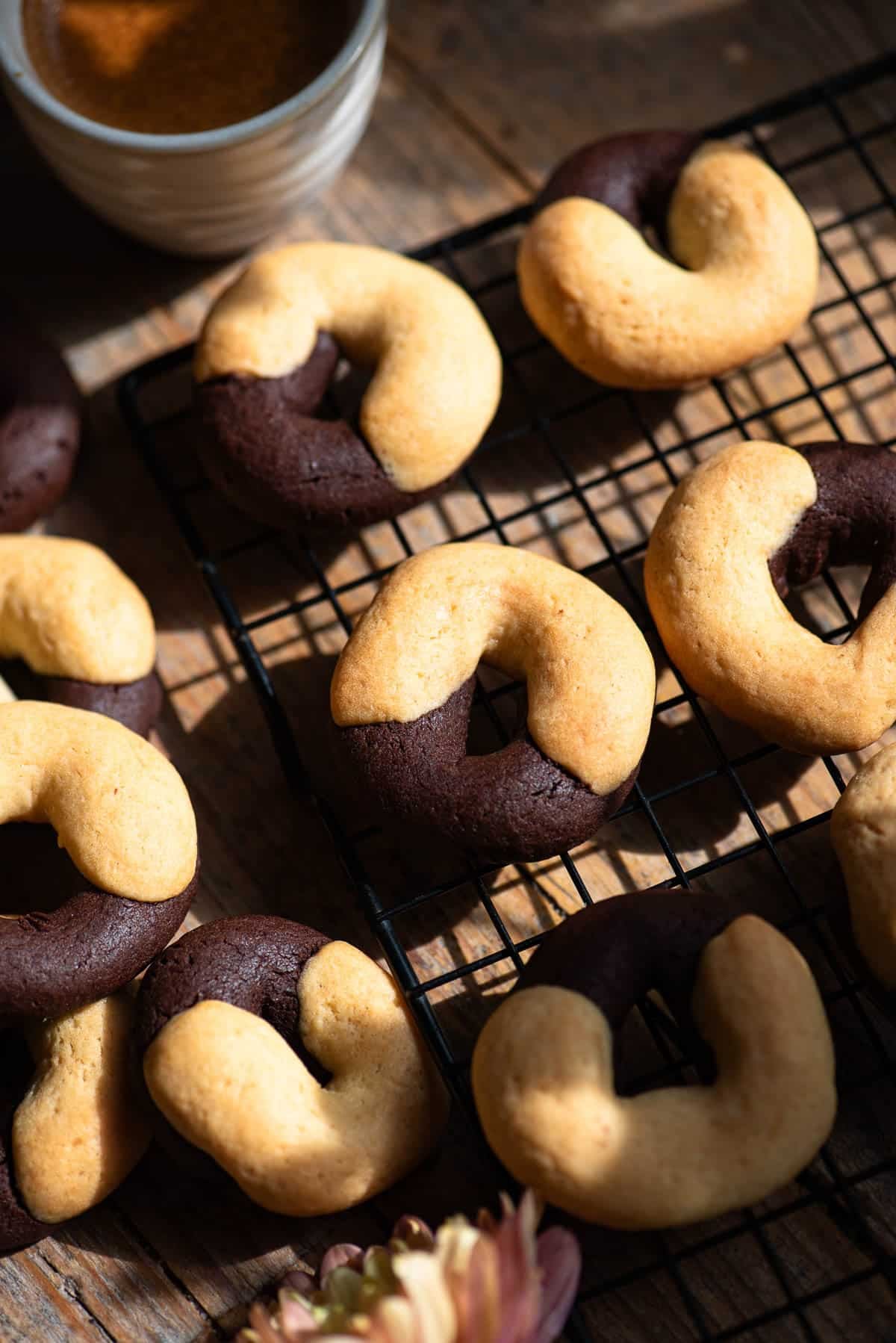 A close up of Italian abbracci cookies (chocolate and cream) on a cooling rack.