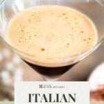 A close up of a frothy and foamy top on an iced coffee in a martini glass.