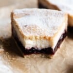 A close up of a slice of sour cherry and ricotta crostata with a bite out.