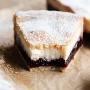 A close up of a slice of sour cherry and ricotta crostata with a bite out.