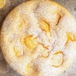 An overhead shot of an Italian sponage cake with pastry cream (Torta Nua) on a travertine background.
