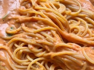 A close up of roasted cherry tomato and ricotta pasta.