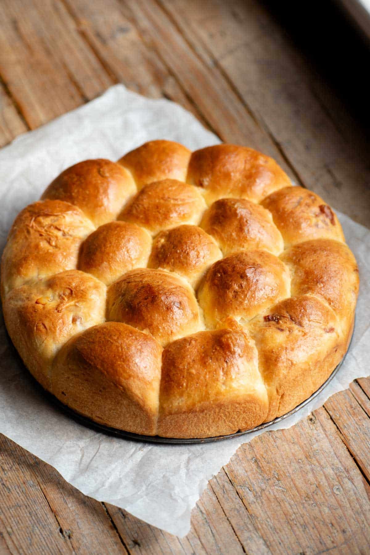 A neapolitan brioche bread (danubio salato) sitting on a rustic wooden surface.
