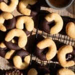 An overhead shot of two tone Italian abbracci cookies on a cooling rack with an espresso at the side.