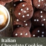A pinterest graphic showing chocolate cookies with star sprinkles on a cooling rack. The text overlay reads Italian Chocolate Cookies - Pan di Stelle Cookies.