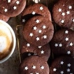 A close up cropped image of Italian chocolate cookies with white stars on them.