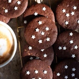 A close up cropped image of Italian chocolate cookies with white stars on them.
